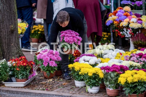  01.11.2018 GDANSK<br />DZIEN WSZYSTKICH SWIETYCH W GDANSKU<br />N/Z KOBIETA UKLADA KWIATY NA STOISKU PRZED CMENRARZEM W GDANSKU OLIWIE<br /> 