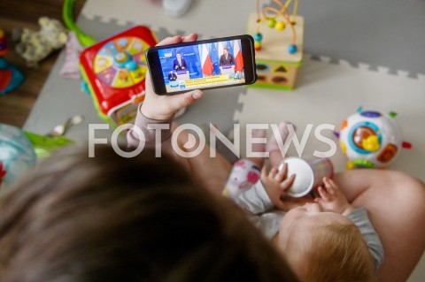  31.03.2020 GDANSK<br />
RODZINA OGLADA KONFERENCJE NA TEMAT KORONOWIRUSA<br />
PREMIER MATEUSZ MORAWIECKI I MINISTER ZDROWIA LUKASZ SZUMOWSKI WPROWADZAJA DODATKOWE OBOSTRZENIA I OGRANICZENIA<br />
N/Z MATKA Z DZIECKIEM OGLADA WYSTAPIENIE PREMIERA<br />
 